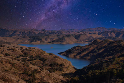 Scenic view of lake and mountains against sky at night