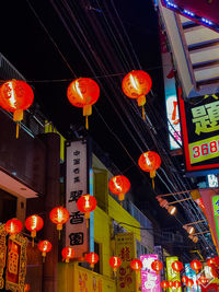 Low angle view of illuminated lanterns hanging in building at night