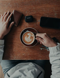 High angle view of hand holding coffee cup