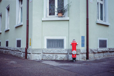 Full length of fire hydrant on street by building