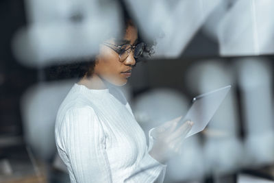 Thoughtful businesswoman using tablet pc in office