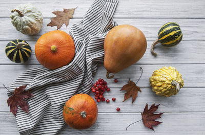 Autumn composition, cozy fall season, pumpkins and leaves on wooden background. 