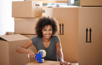 Smiling woman packing boxes at home