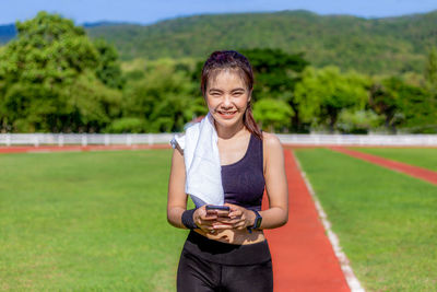 Young man smiling woman standing on grassy field