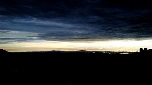 Silhouette of landscape against cloudy sky