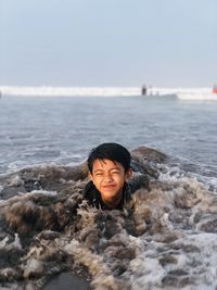 Portrait of young man in sea with having fun 