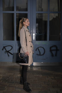 Portrait of young woman standing in city