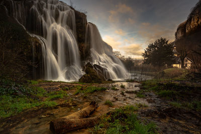 Scenic view of waterfall against sky