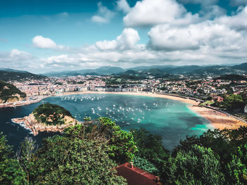 High angle view of bay and cityscape against sky