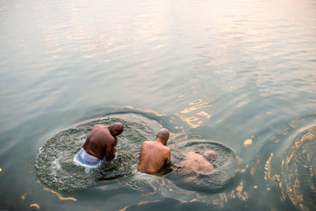 HIGH ANGLE VIEW OF MAN SWIMMING ON SEA