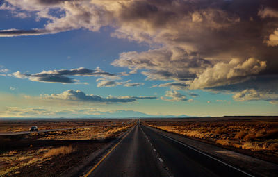 Empty road along countryside landscape