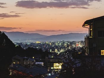 High angle view of illuminated city against sky at sunset