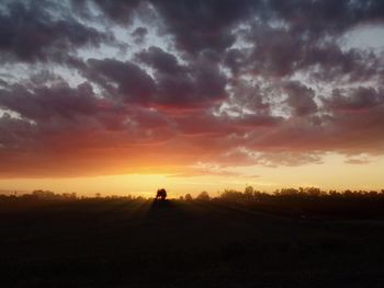 Silhouette people on field against scenic sky