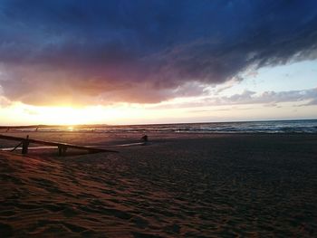 Scenic view of beach against cloudy sky