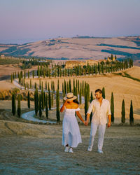 Friends standing on land against sky