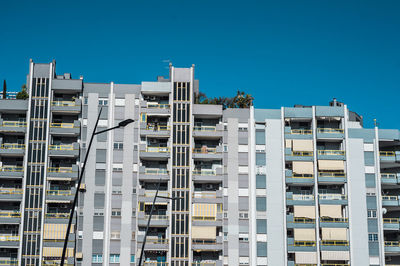 Low angle view of modern buildings against clear blue sky