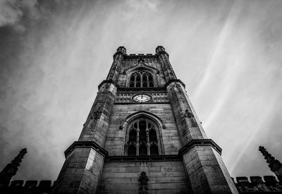 Low angle view of clock tower of historic church against sky