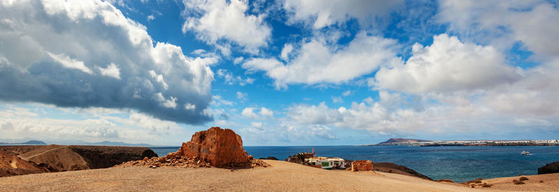 Panoramic shot of rocks on beach against sky