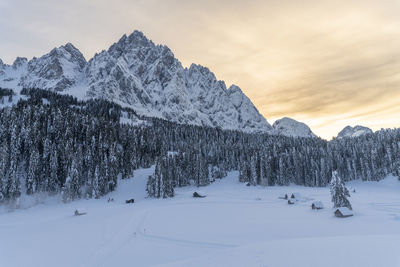 Snow covered land and mountains against sky