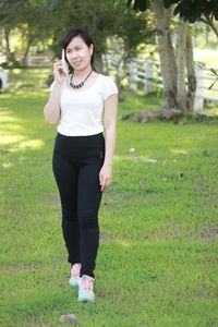 Full length of young woman standing on field