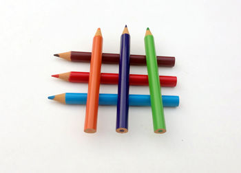 High angle view of colored pencils against white background