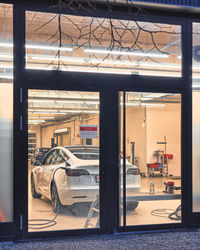 Cars on street seen through glass window