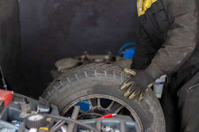 Senior experienced mechanic teaches his colleague how to repair a car