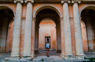 Portrait of young woman standing in front of building