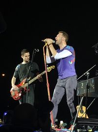 People playing guitar at music concert