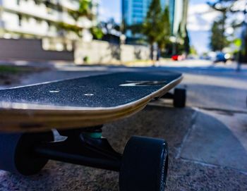 Close-up of skateboard on road in city