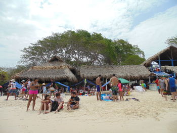 Crowd on sand against sky