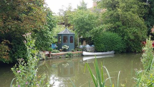 Gazebo by lake against trees