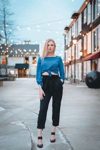 Full length of young woman standing in city