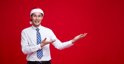 Young man wearing mask against red background