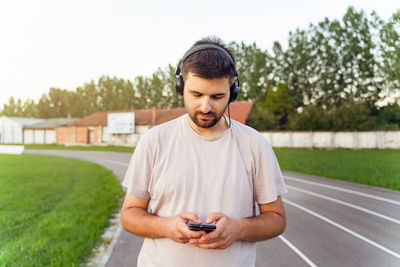 Young man using mobile phone while looking away