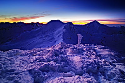 Scenic view of snowcapped mountains against sky during sunset