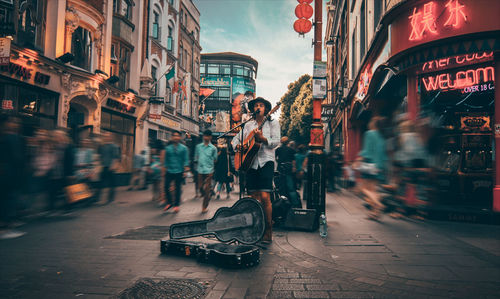 People on city street against sky