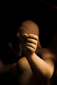 Close-up of human hand against black background