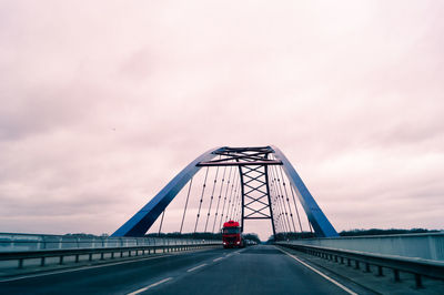 Suspension bridge against cloudy sky