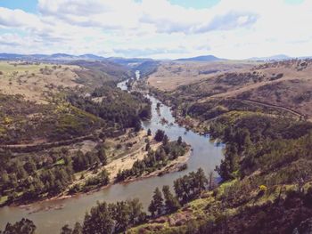 Scenic view of river against cloudy sky