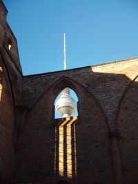 Low angle view of illuminated tower against blue sky