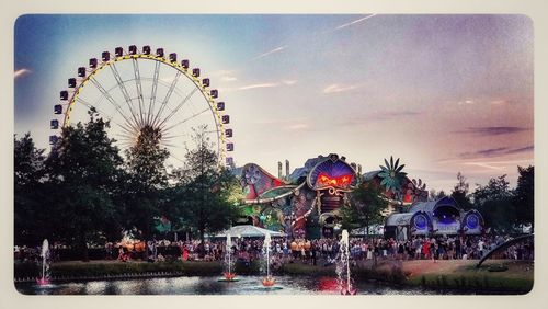 People in amusement park against sky