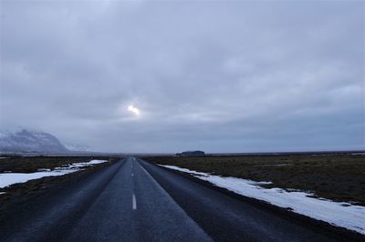 Empty road against sky during winter