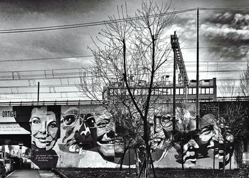 Bare trees by building against sky