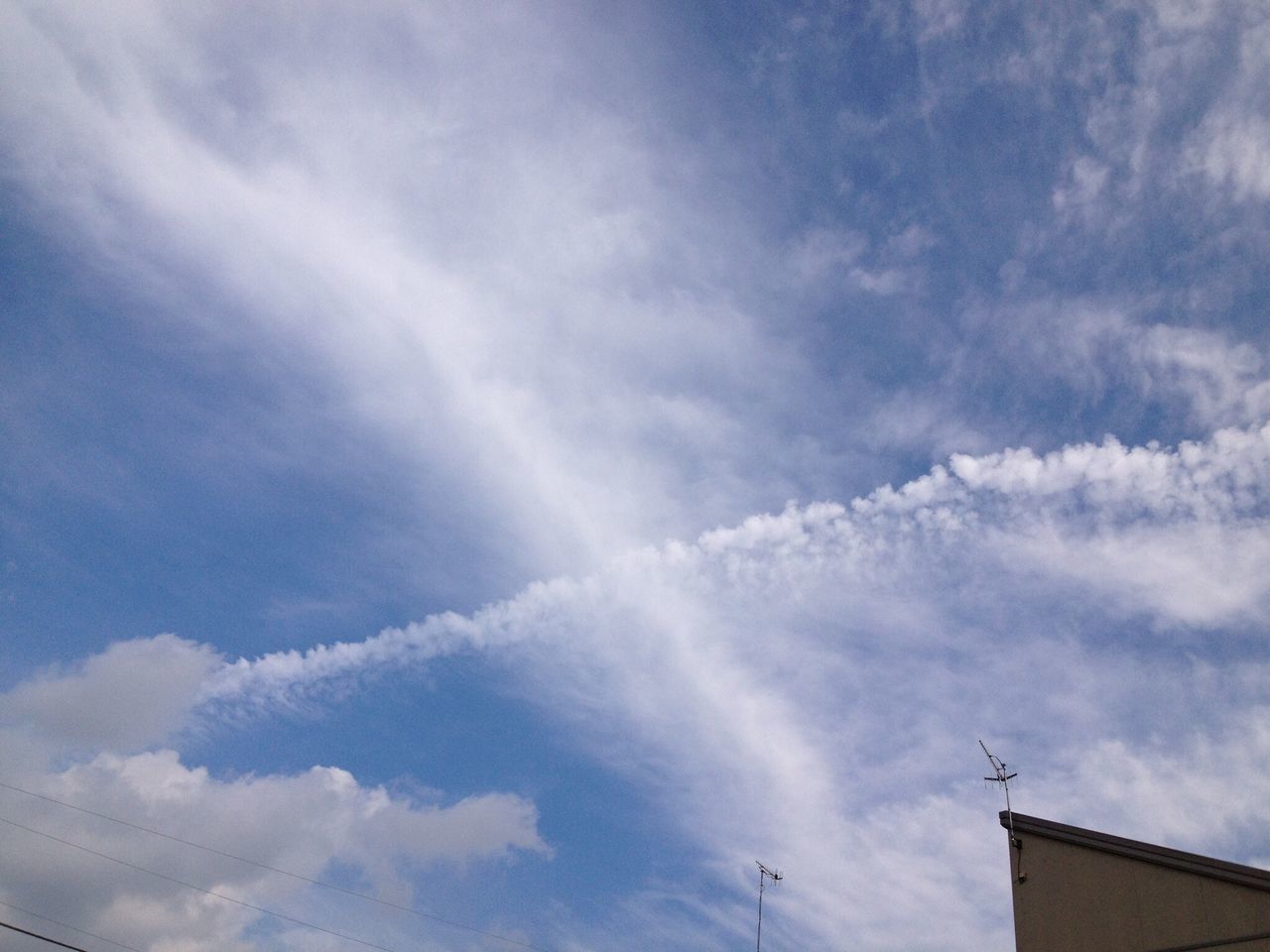 sky, low angle view, cloud - sky, cloudy, cloud, building exterior, built structure, beauty in nature, blue, architecture, nature, outdoors, day, high section, scenics, no people, cloudscape, tranquility, vapor trail, weather