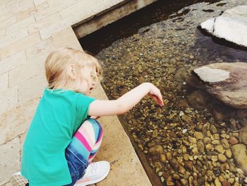 High angle view of girl playing by pond