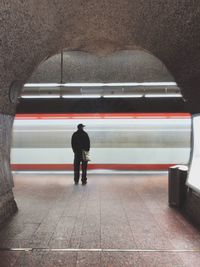 Rear view of man walking in subway