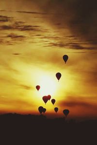 Hot air balloons in sky at sunset