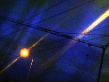 Low angle view of illuminated street light against blue sky