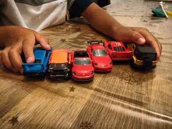 Midsection of man holding toy car at table